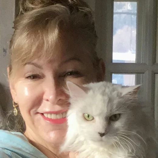 Deborah Felin-Magaldi holding a long-haired white and gray cat